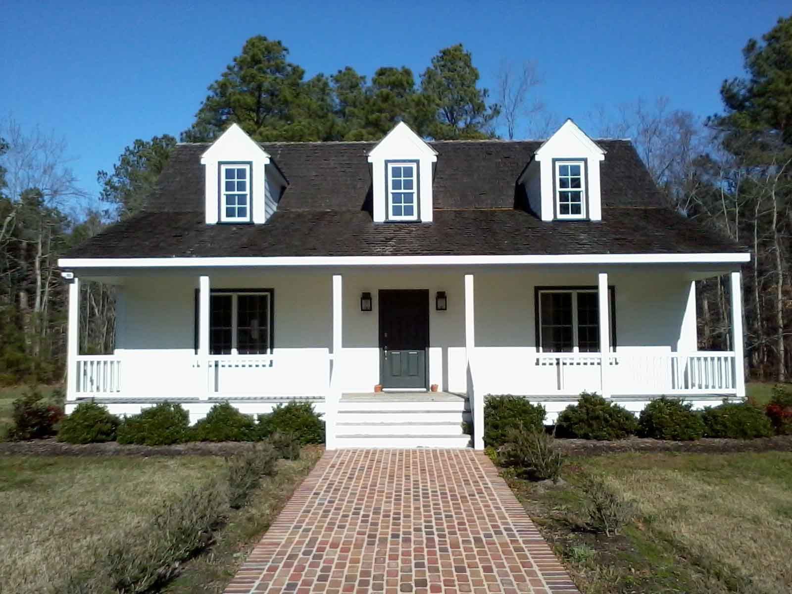 A white house with a brick walkway leading to it