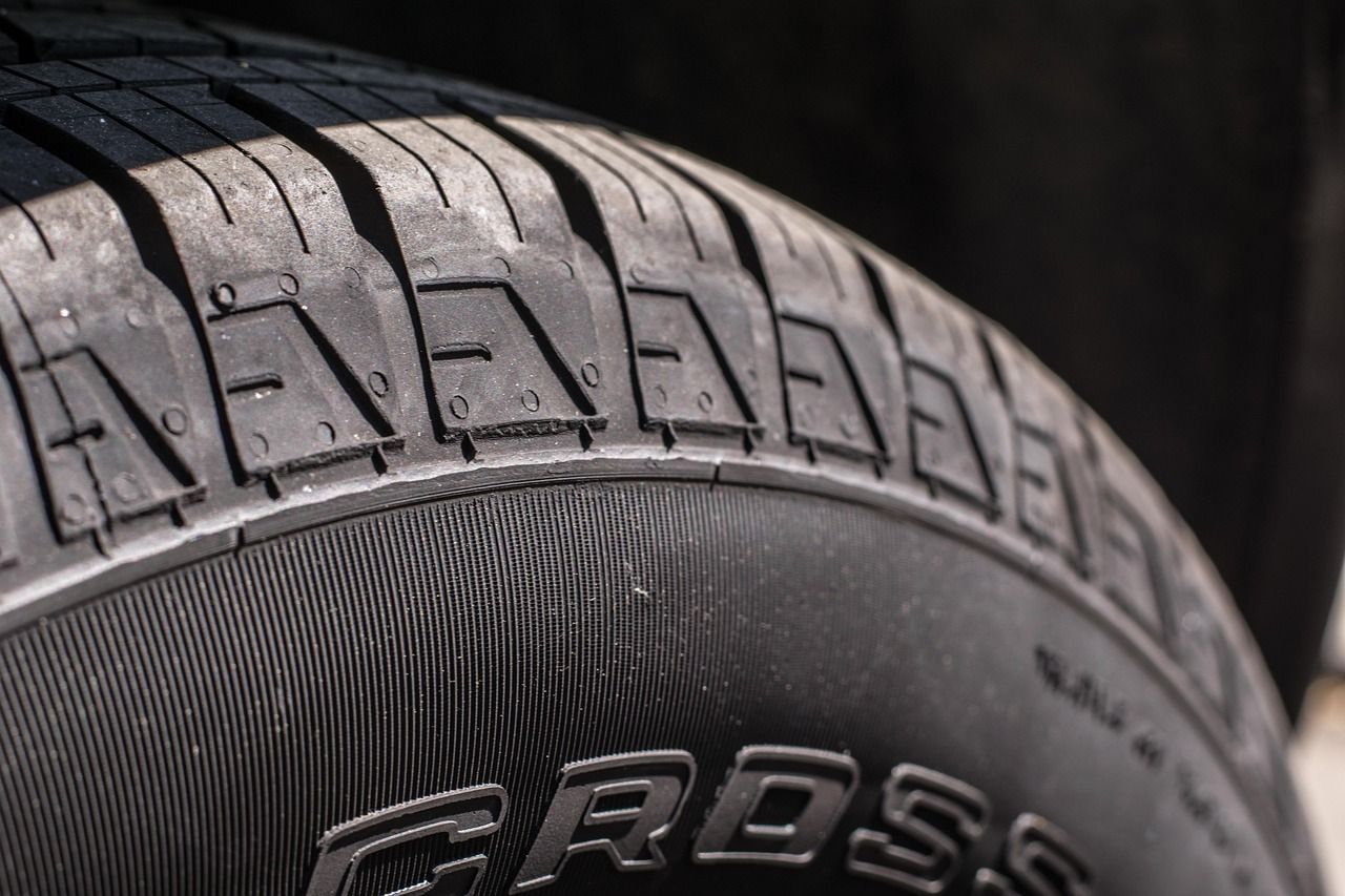 Close-up of a black tire with distinct tread pattern, text 