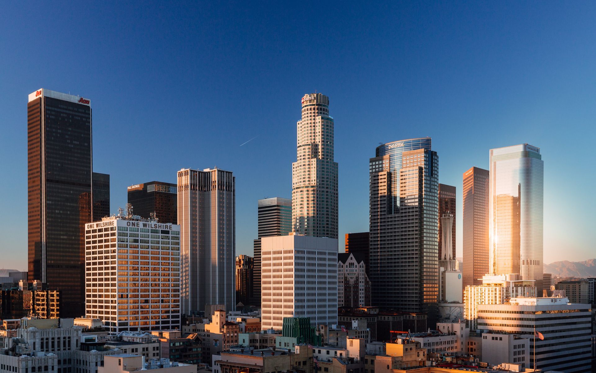 Los Angeles skyline with tall skyscrapers under a clear blue sky during the day.