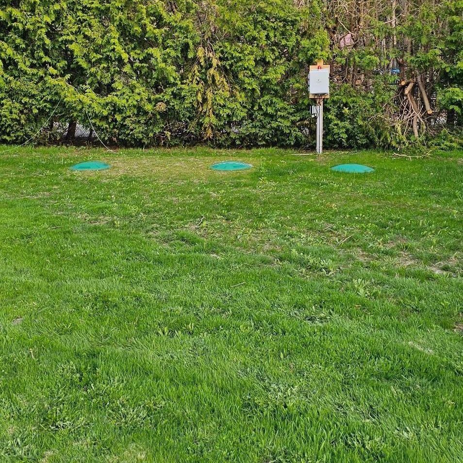 Septic Installation - A lush green lawn with a sign in the middle of it.
