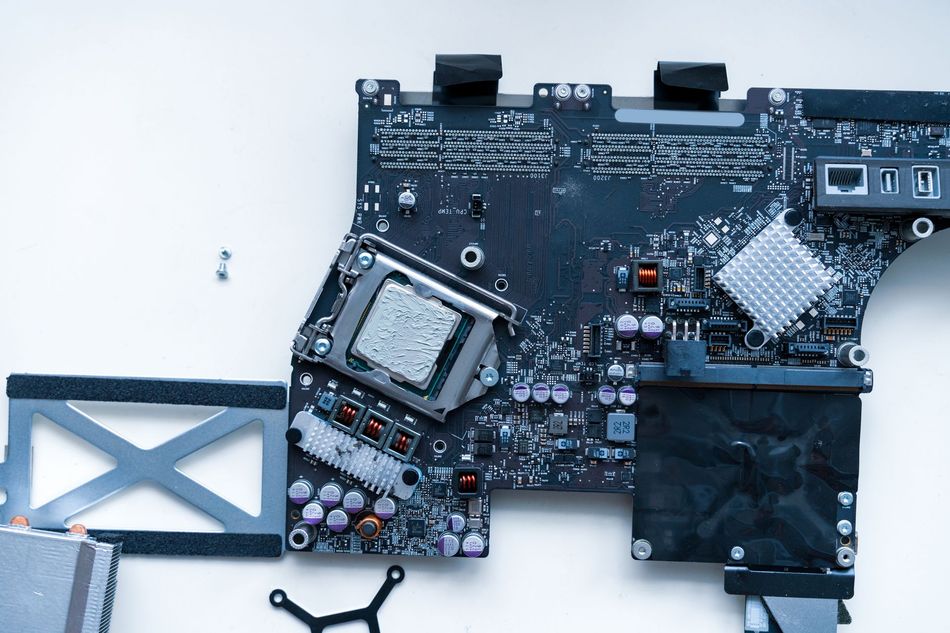 Una scheda madre di un computer smontata con processore e vari componenti 