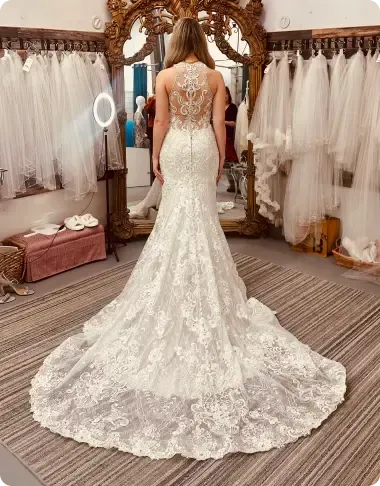 A woman in a wedding dress is standing in front of a mirror.