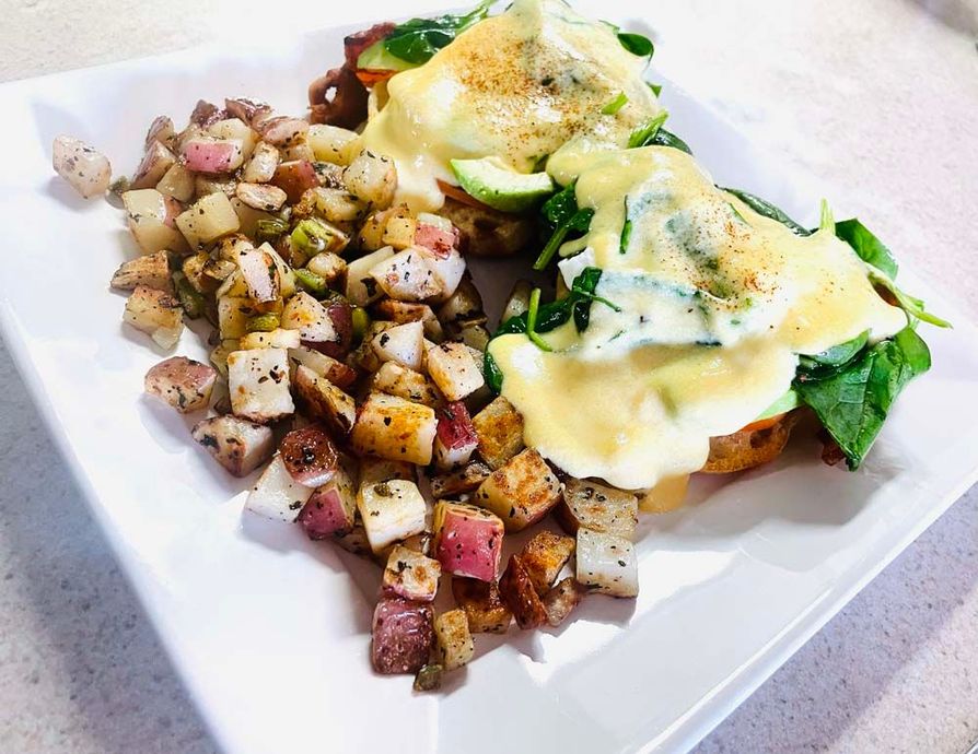 A plate of food with potatoes and eggs on a table.