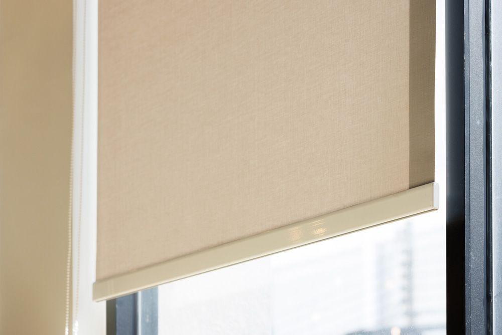 A man on a ladder is working on a screened in area