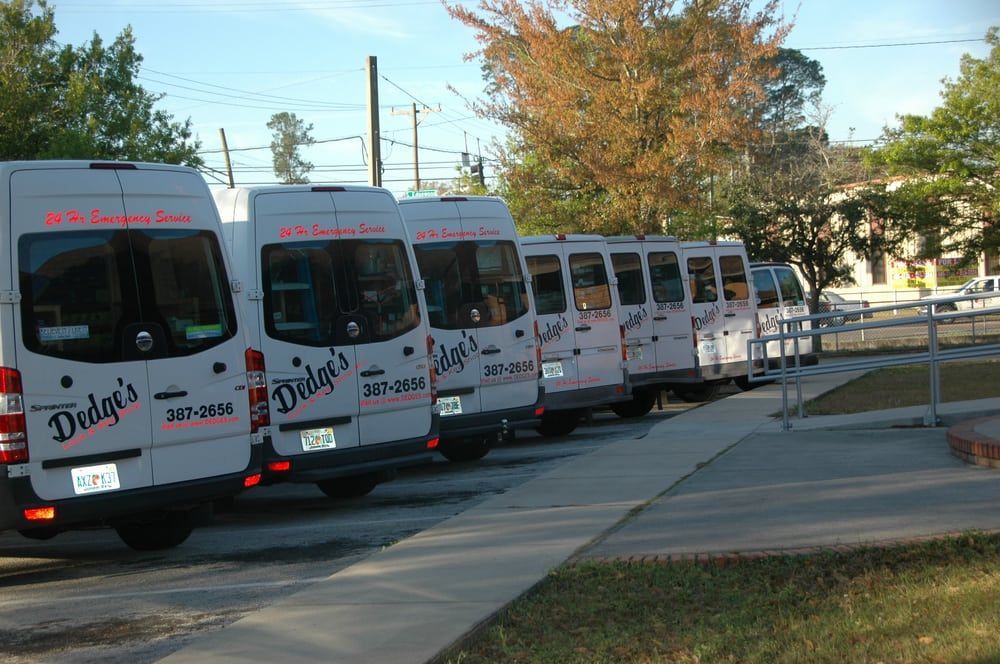 A row of dodge 's vans are parked in a parking lot