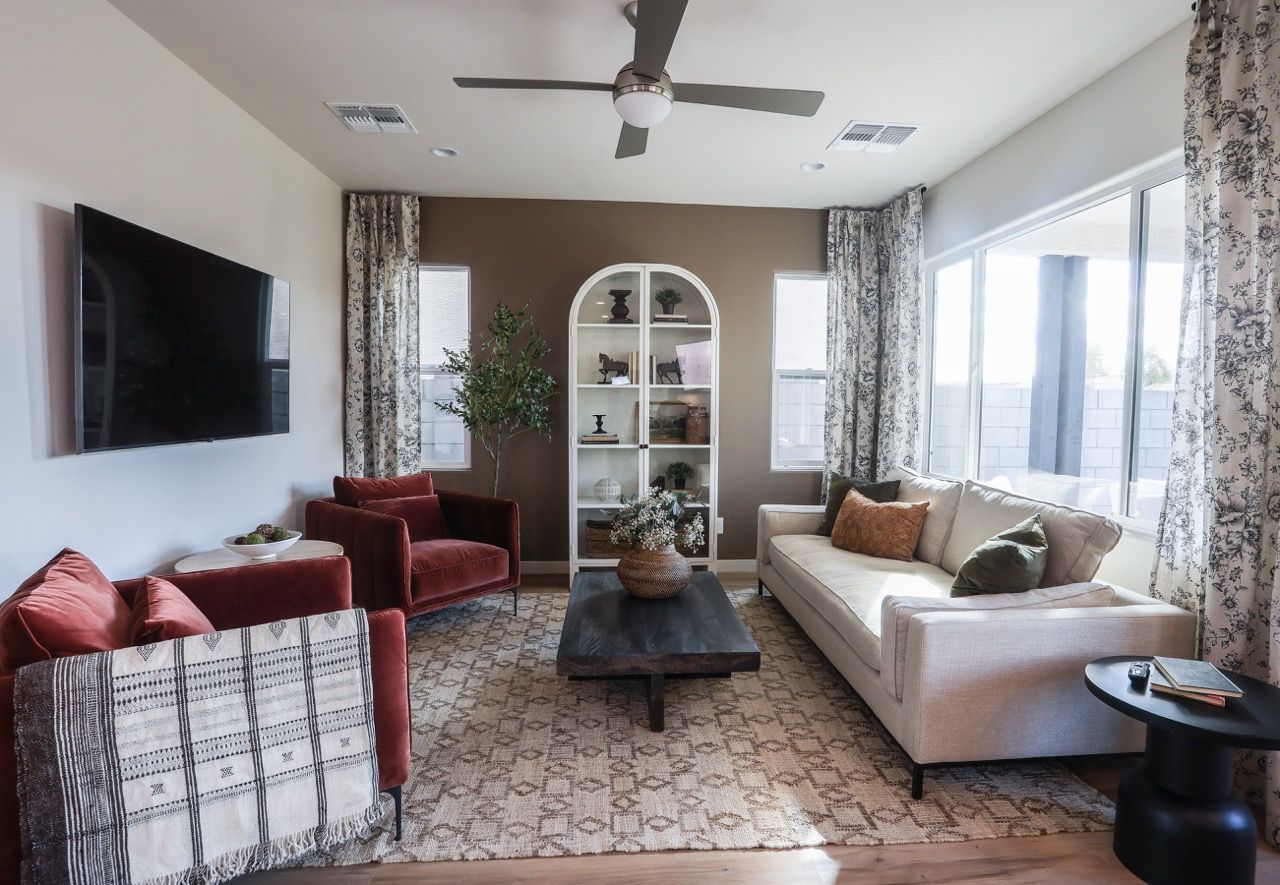 a living room with a sectional couch and a ceiling fan .