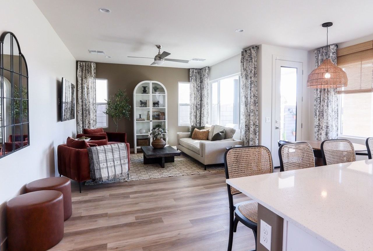 a living room with a sectional couch and a ceiling fan .