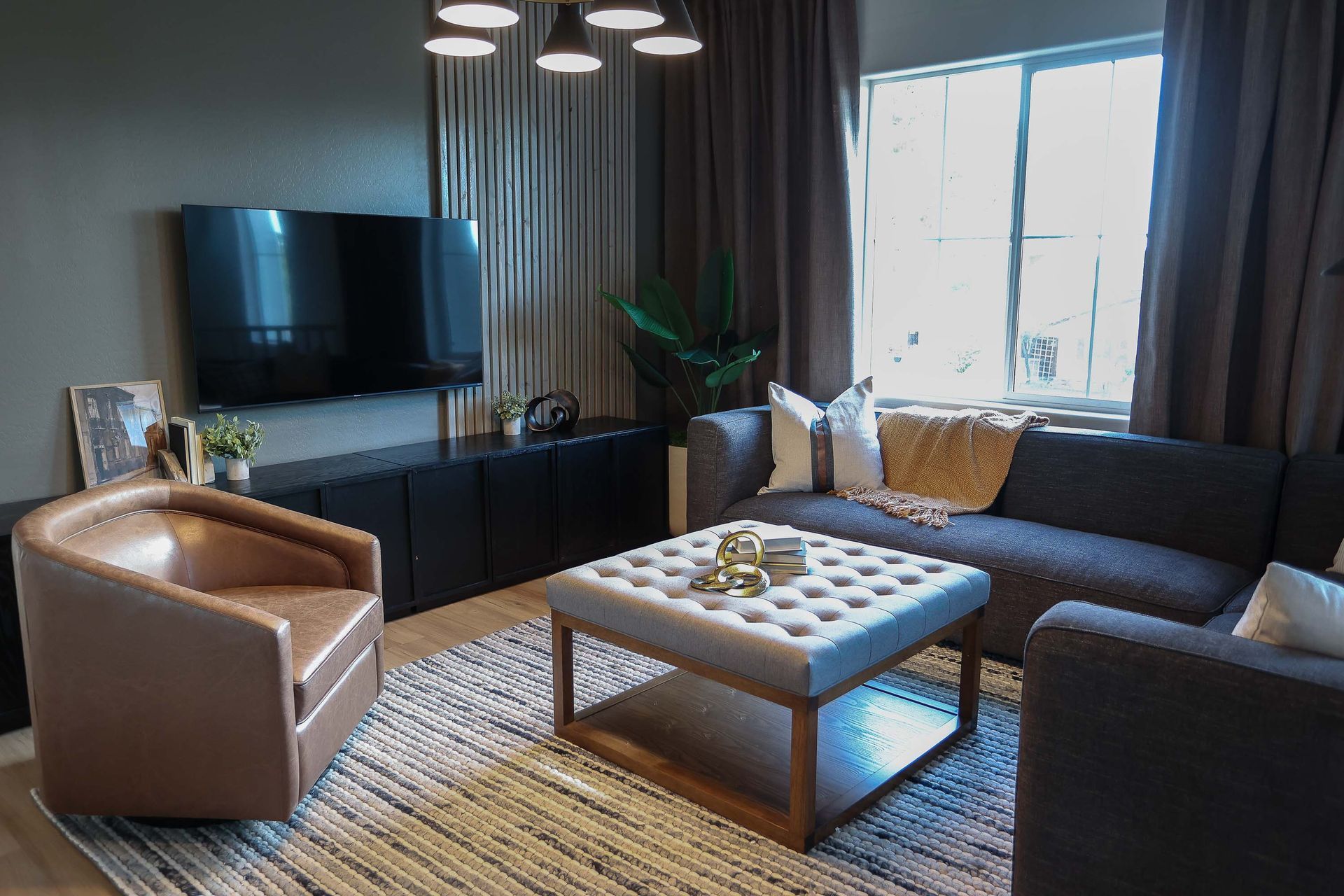a living room with a sectional couch and a ceiling fan .