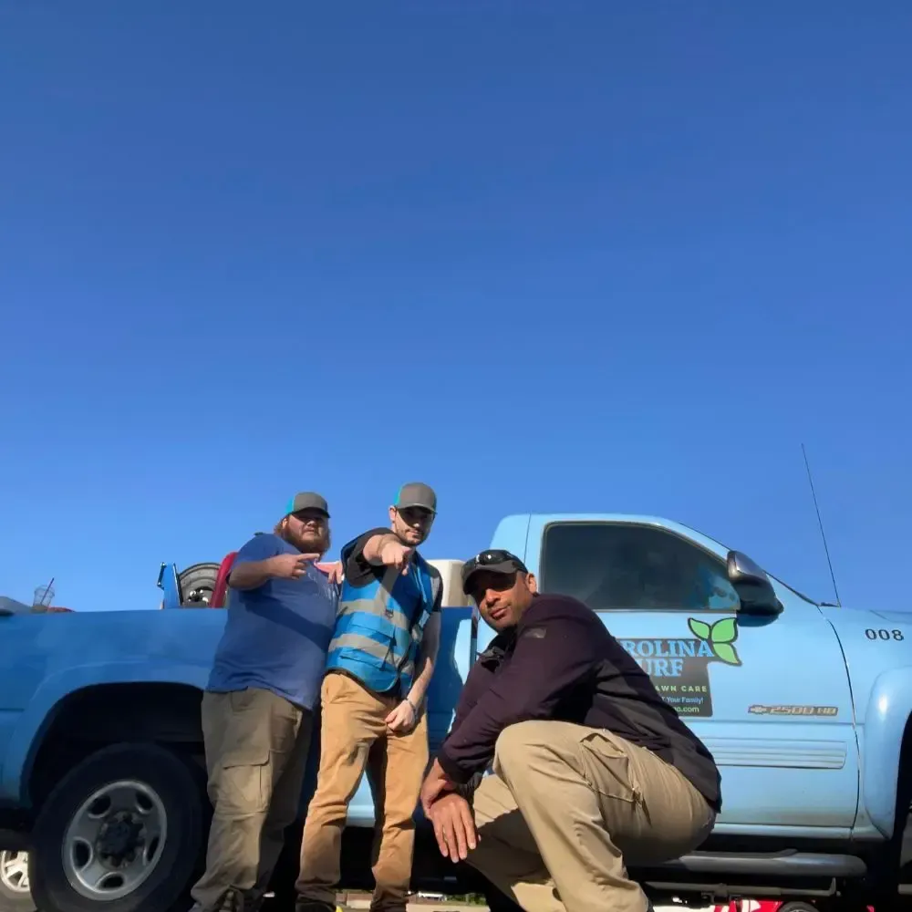 3 Carolina Turf employees posing in front of a spray truck in Apex, NC.