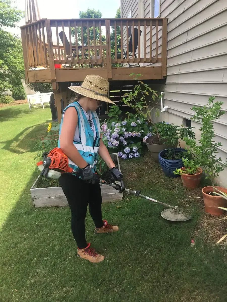 A female Carolina Turf employee servicing a customer's yard in Fuquay-Varina, NC.