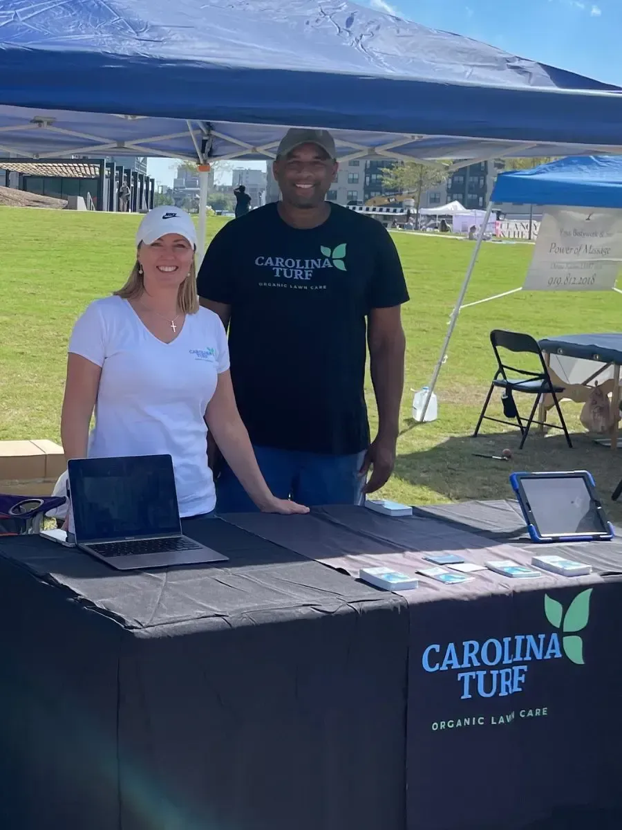 Carolina Turf owners standing at a booth at an organic festival.