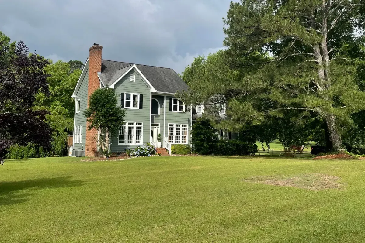 A green, weed-free organic lawn in front of a two-story house