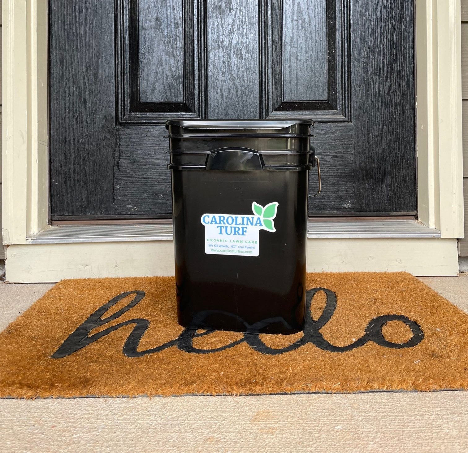 Carolina Turf compost bucket in front of a door