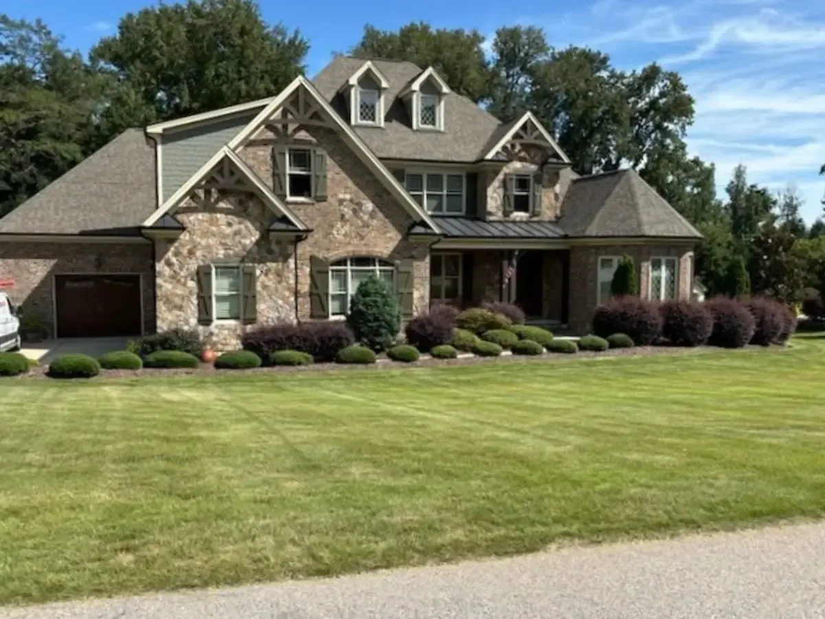 A brick home in Fuquay-Varina, NC with green, organically treated front lawn.