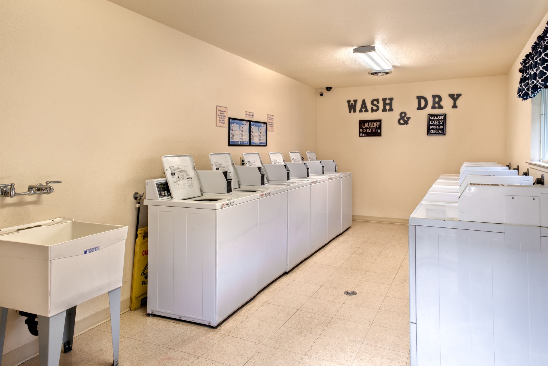 Laundry room with washers and dryers, utility sink, and