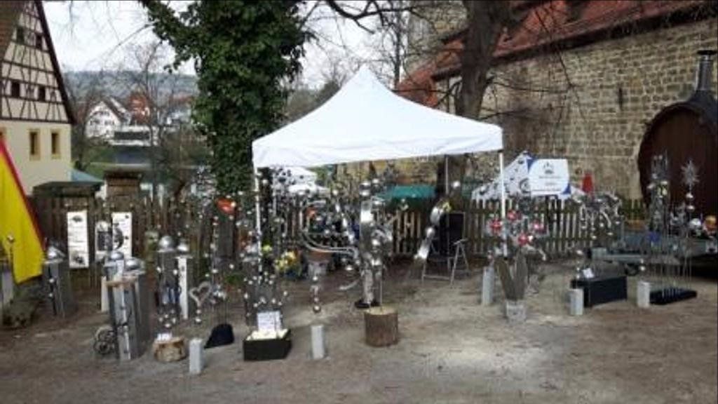 Mitten in einem Park steht ein weißes Zelt.