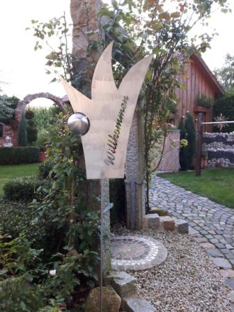 Ein Schild in einem Garten mit der Aufschrift „Willkommen“