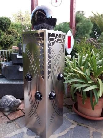 Eine Edelstahlsäule mit einer schwarzen Kugel darauf