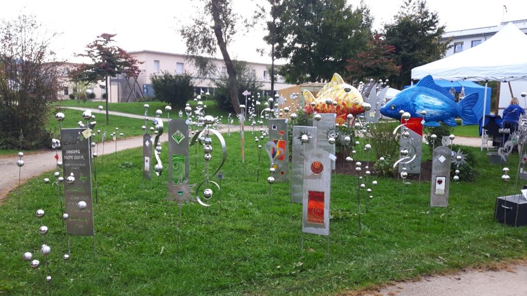 Mehrere Skulpturen stehen auf einem üppigen grünen Feld.