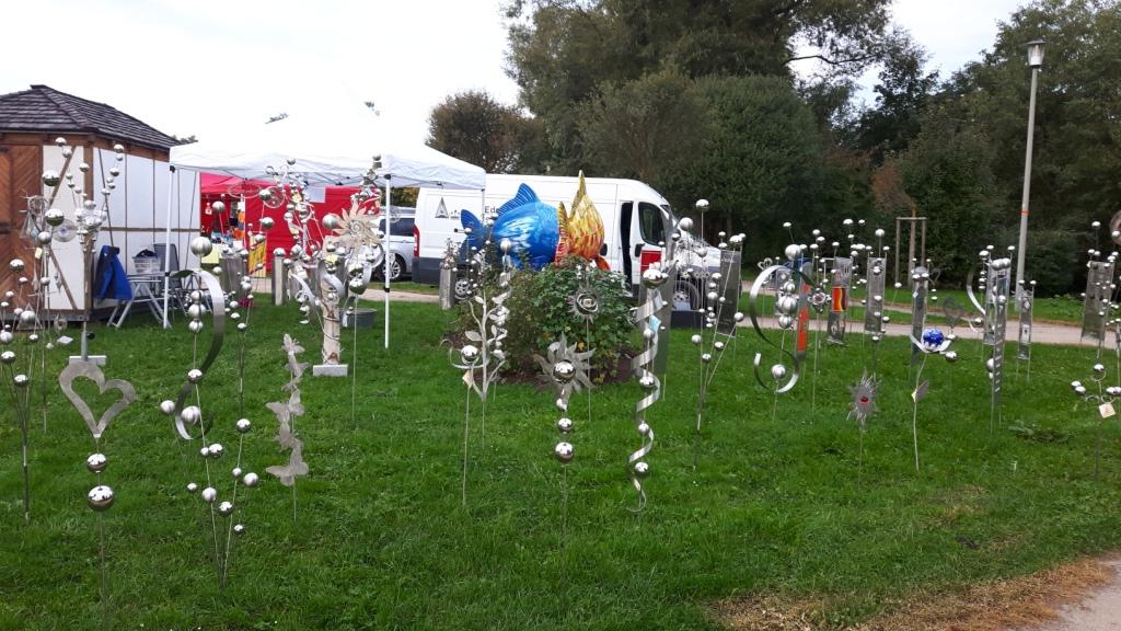 Eine Reihe von Skulpturen sitzen im Gras in einem Park