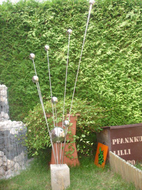 Eine Skulptur in einem Garten mit einem Schild mit der Aufschrift Pfanner