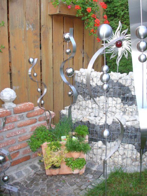 Eine Topfpflanze steht vor einem Holzzaun