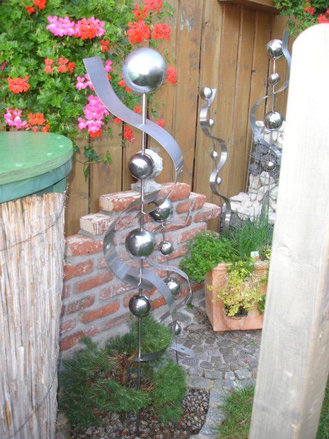 Ein Garten mit einer Edelstahlskulptur in der Mitte