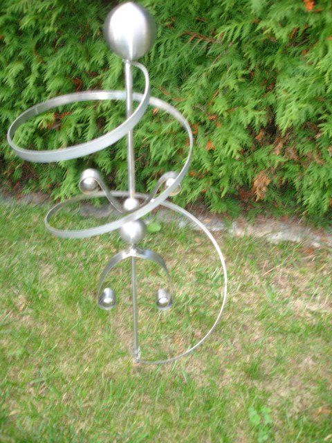 Eine Metallskulptur steht auf einem üppigen grünen Rasen.