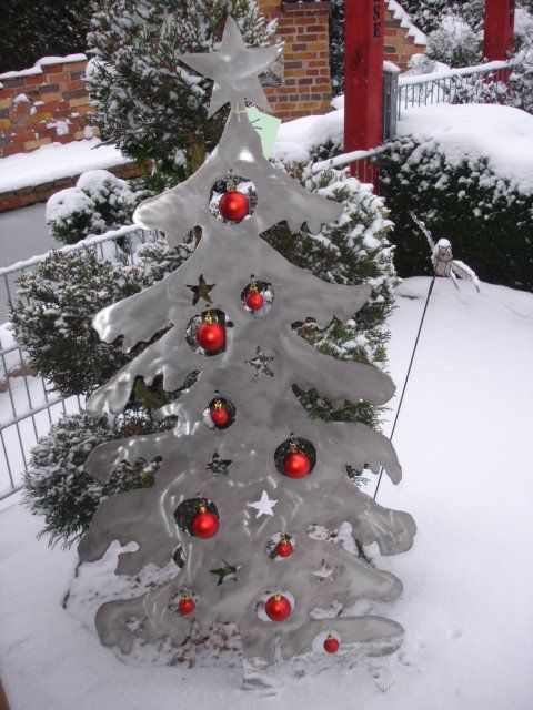 Ein silberner Weihnachtsbaum mit roten Verzierungen und einem Stern an der Spitze