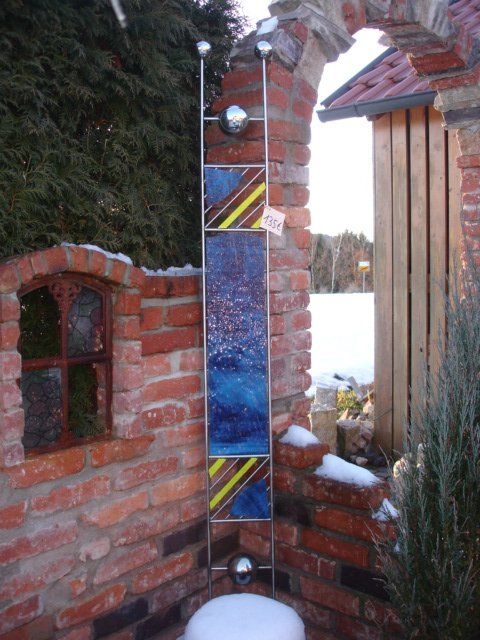 Eine Backsteinmauer mit einer Skulptur aus Buntglas darauf