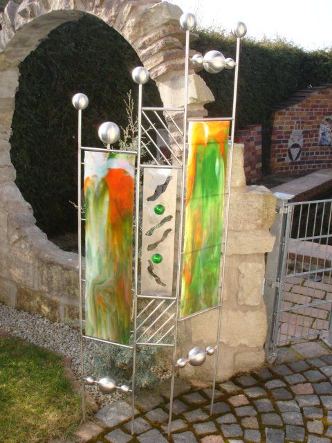 Ein steinerner Torbogen mit einer Skulptur im Hintergrund