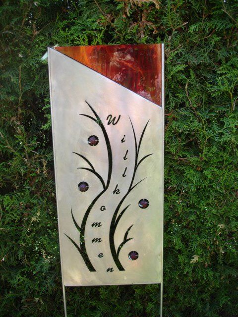 Eine Metallskulptur mit Bäumen und dem Buchstaben W darauf