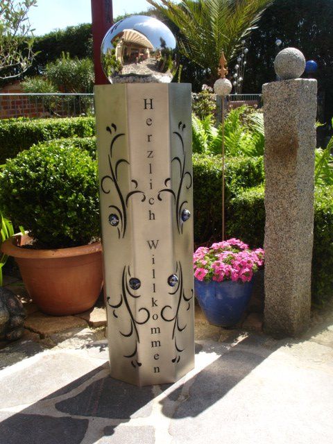 A stainless steel pillar with the words herzlich willkommen written on it