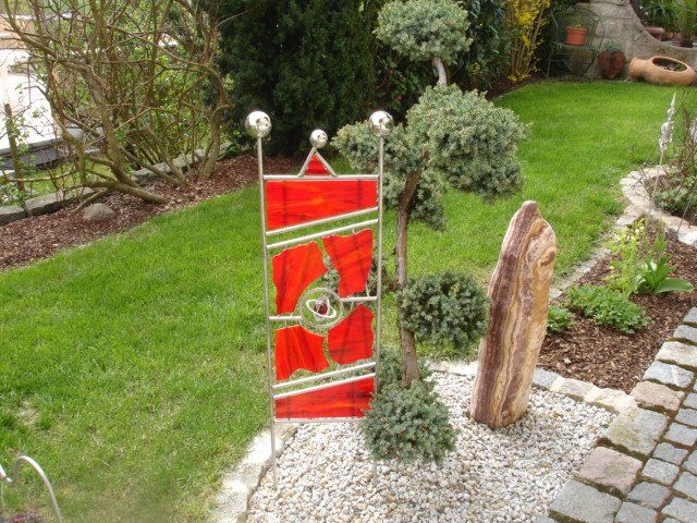 Ein Garten mit einer roten Fahne und einem Baum