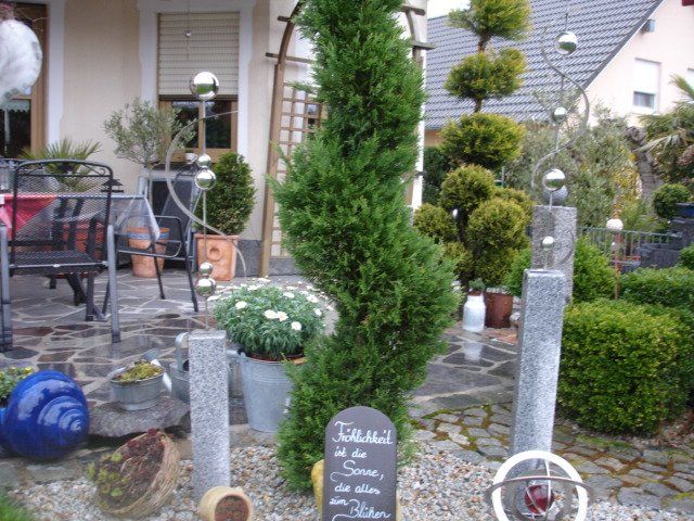 Ein Garten mit einem Baum und einem Schild mit der Aufschrift „Die Sonne“