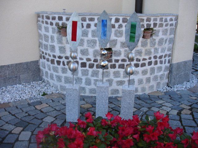 Eine Backsteinmauer mit ein paar Blumen davor