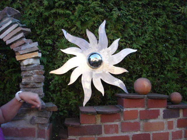 Eine Ziegelmauer mit einer Skulptur einer Sonne darauf