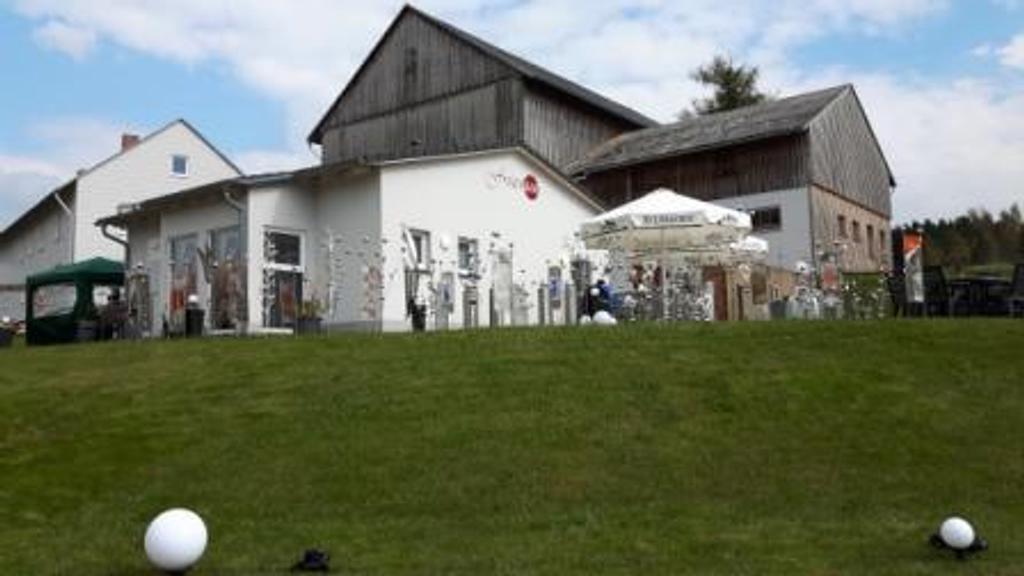 Eine Gruppe von Menschen steht auf einer Wiese vor einem Gebäude.