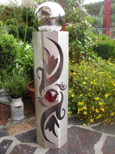 Eine Edelstahlskulptur mit einer Kugel darauf