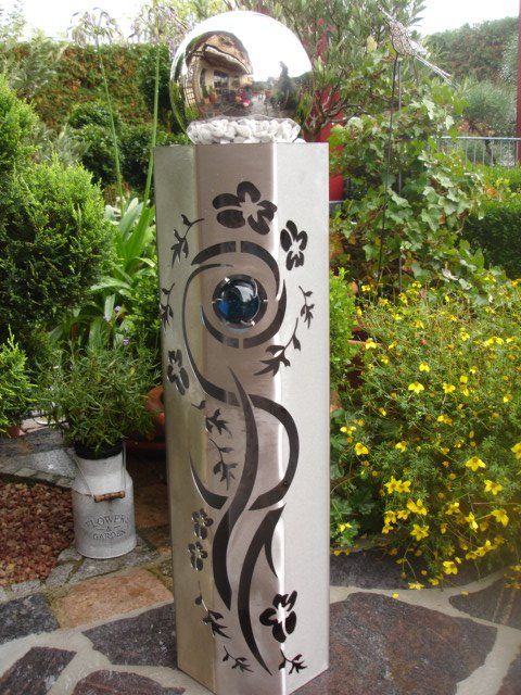Eine Edelstahlsäule mit Blumen darauf