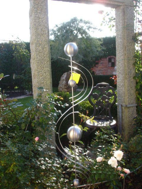 Eine Skulptur in einem Garten mit einem gelben Etikett darauf