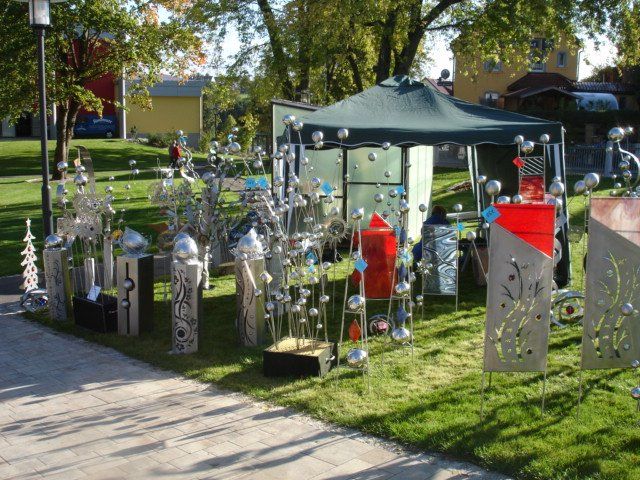 Eine Ausstellung von Skulpturen in einem Park mit einem Zelt im Hintergrund