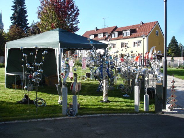 Ein grünes Zelt steht im Gras vor einem Haus