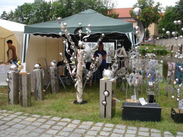 Eine Ausstellung von Edelstahlskulpturen vor einem Zelt