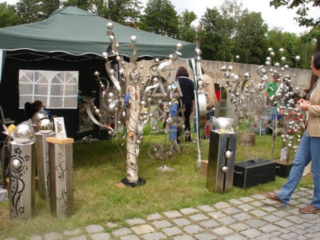 Eine Frau steht vor einem Zelt mit Edelstahlskulpturen