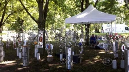 Ein weißes Zelt steht inmitten eines von Bäumen umgebenen Parks.