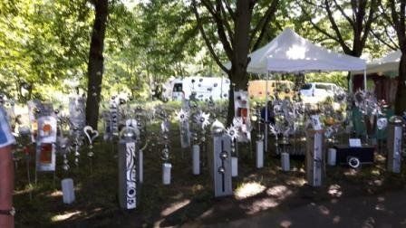 Eine Person steht vor einer Skulpturenausstellung in einem Park.