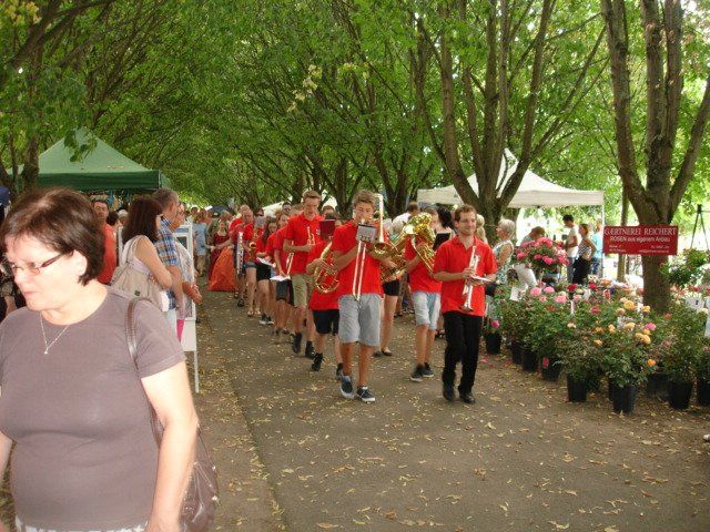 Eine Gruppe von Menschen marschiert einen Bürgersteig entlang, im Hintergrund sind Bäume zu sehen