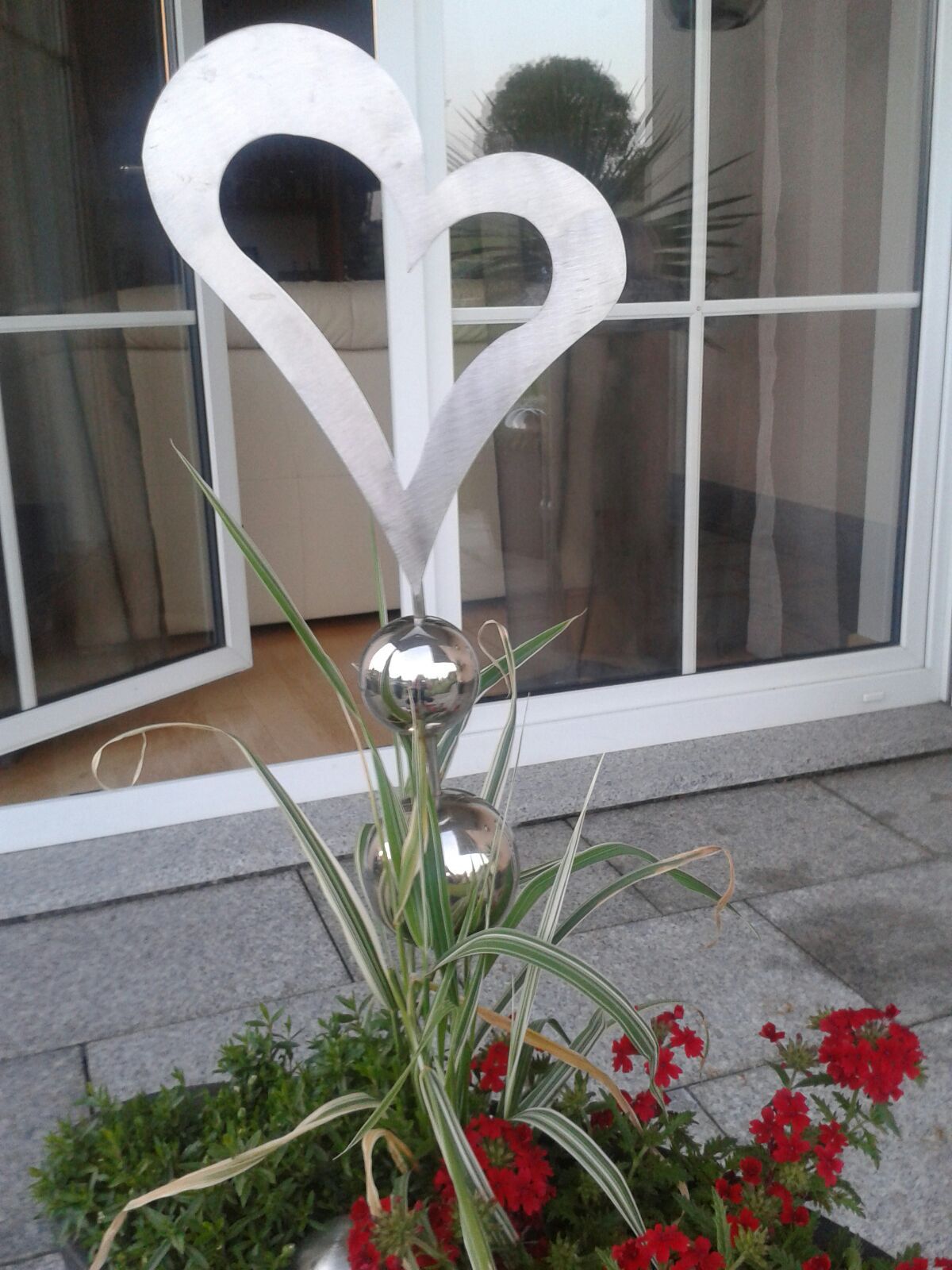 Ein Blumentopf mit Blumen und einem Herz in der Mitte