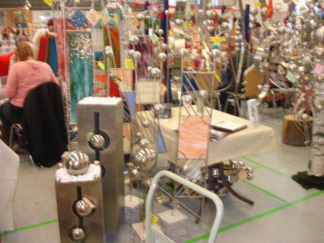 Eine Frau sitzt an einem Tisch in einem Geschäft, umgeben von viel Dekoration